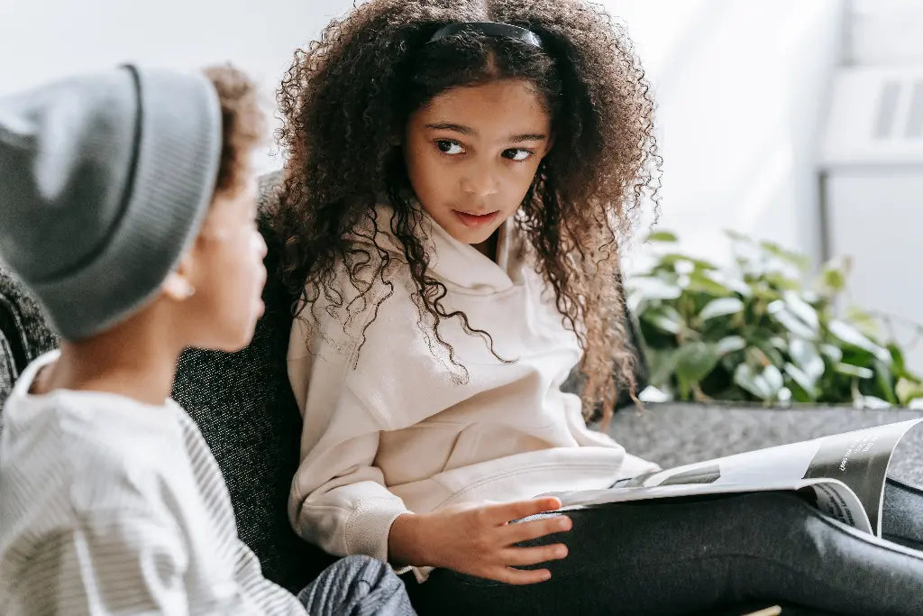 Two kids having a thoughtful conversation on a couch. Image showing wise kids.